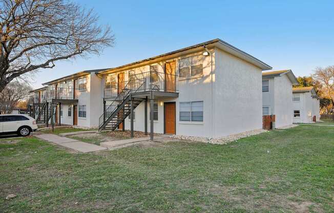 A white building with a tree in front of it.