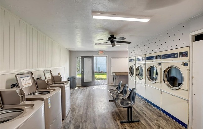 a laundry room with washers and dryers and a ceiling fan