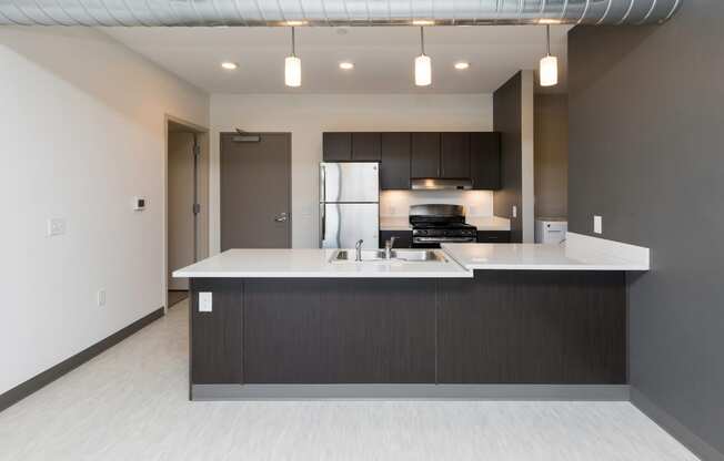 Modern open-concept kitchen and living area with stainless steel appliances.