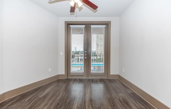 a living room with a door and a ceiling fan