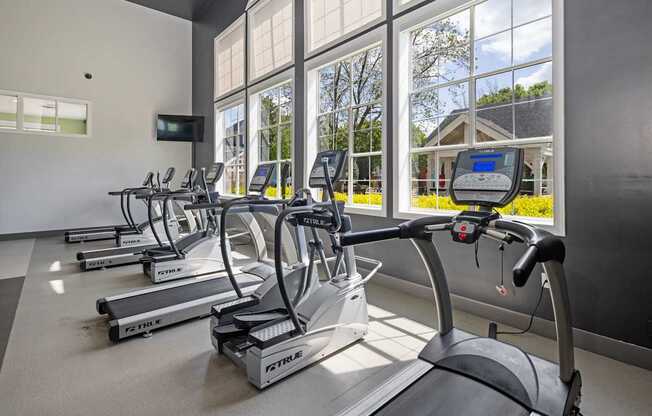 A gym with treadmills and a television.