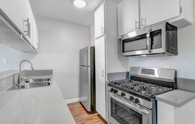 a kitchen with stainless steel appliances and white cabinets