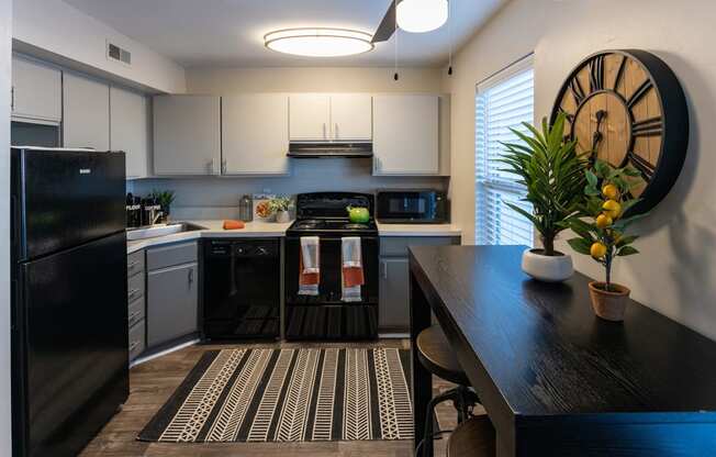 a kitchen with white cabinets and a black and white rug