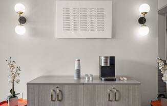 a cupboard with a coffee maker and a tablet on it in a living room