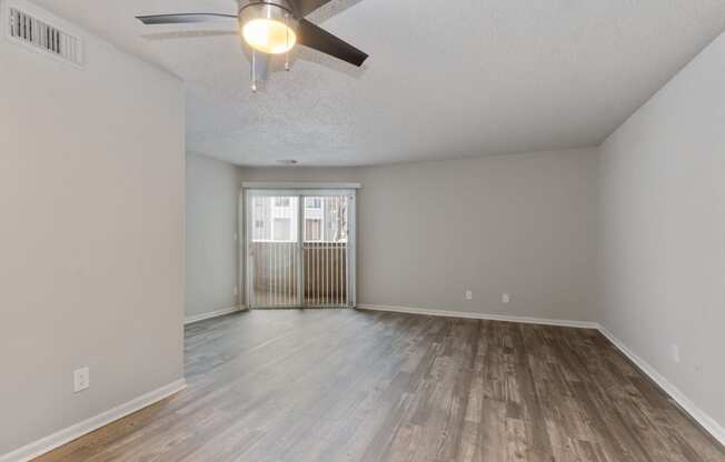 the spacious living room with wood flooring and a ceiling fan at Eastwood Crossings, Kansas City