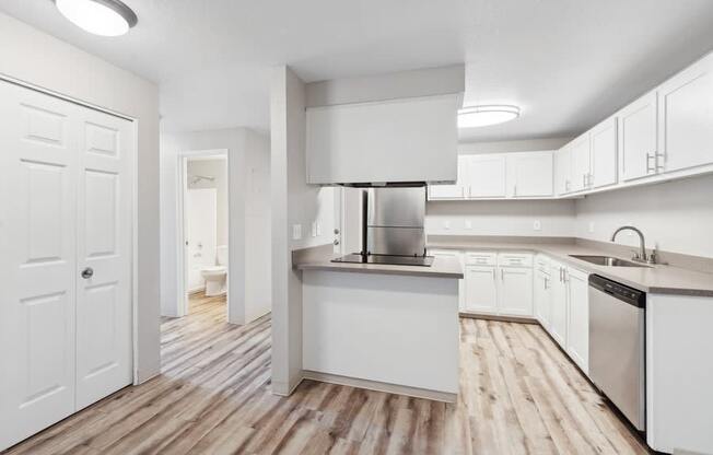 a large white kitchen with white cabinets and stainless steel appliances