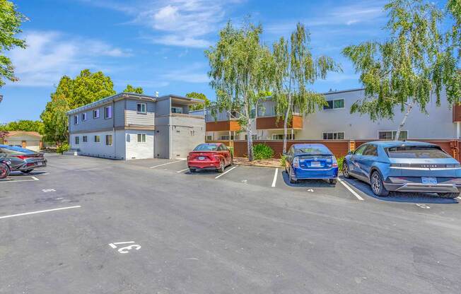 A parking lot with cars and a building in the background.