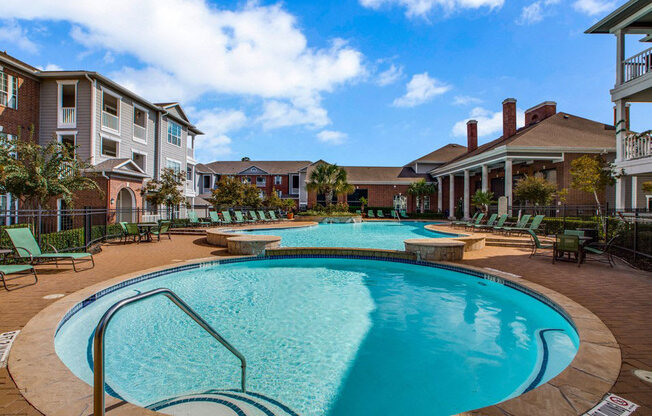 a large swimming pool with a building in the background  at Volare at the Woodlands, The Woodlands, TX, 77384