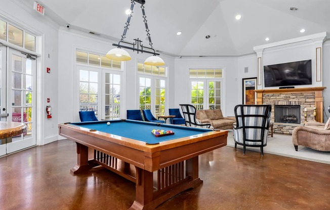 A pool table is in the middle of a room with a fireplace and a television.