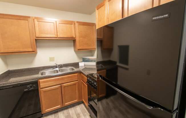 This is a photo of a kitchen with honey oak cabinets and black appliances in a 560 square foot 1, 1 bath apartment at Park Lane Apartments in Cincinnati, OH.