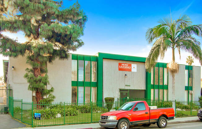 a red truck parked in front of a green and white building