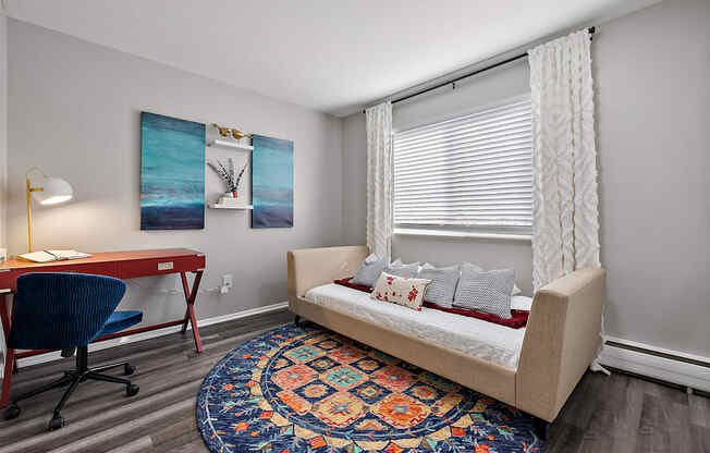 a living room with a couch and a desk with a chair