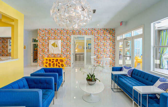 a lobby with blue couches and yellow walls