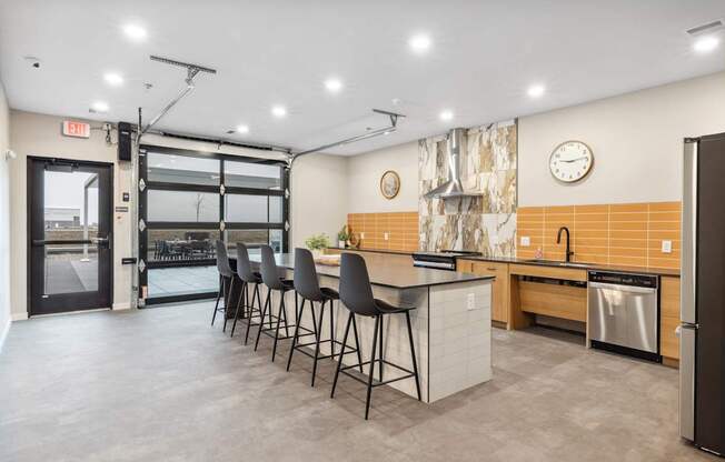 a kitchen with an island and chairs in front of a door