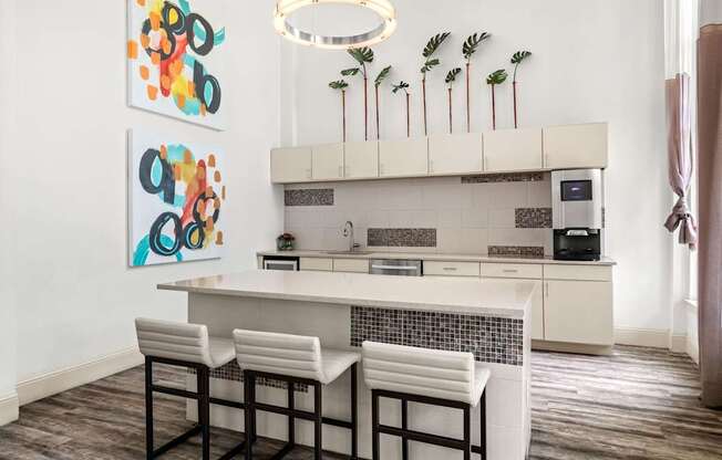 A kitchen with a white counter and bar stools.