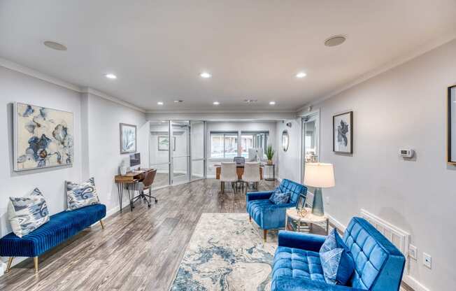 a living room with blue couches and a dining room with a table and chairs