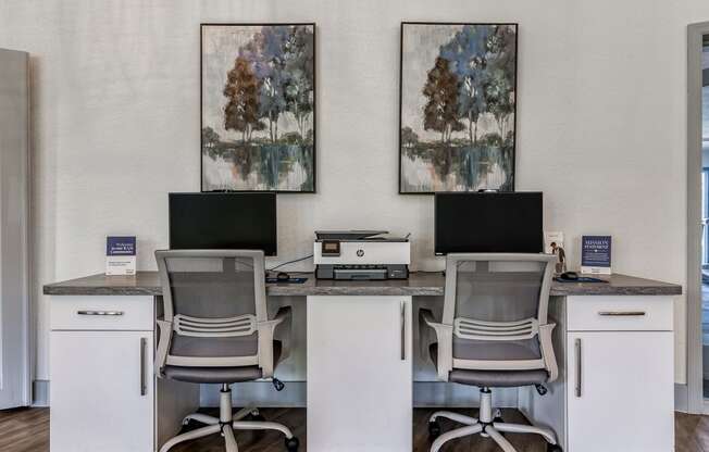 an office with three desks with computers and chairs