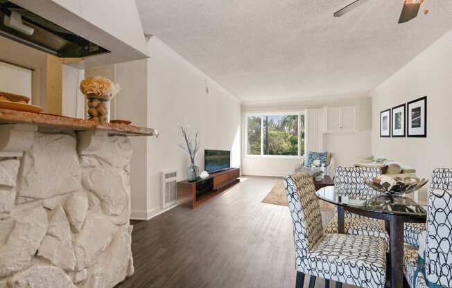 Dining area with ceiling fan, wood style floors throughout, breakfast bar