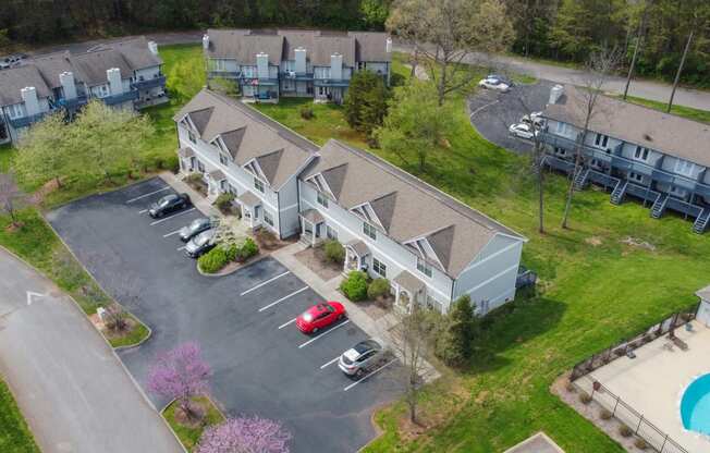 an aerial view of three buildings with cars parked in front of them