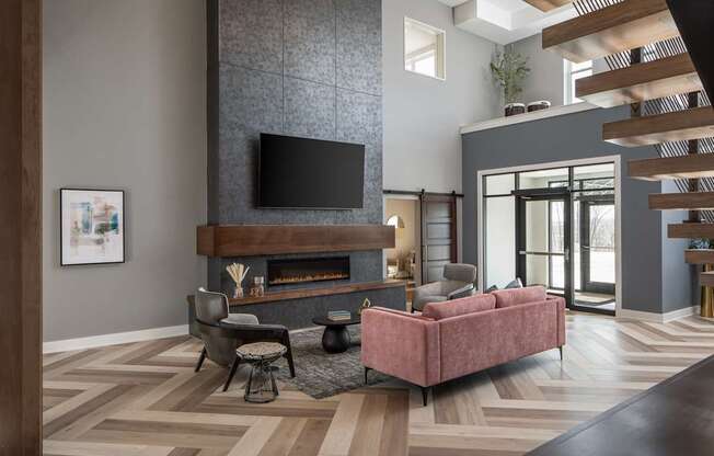A living room with a pink couch and a fireplace.