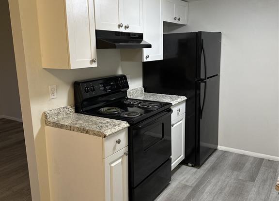 a kitchen with a black stove and a refrigerator