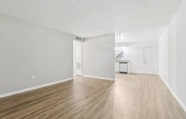 A room with wooden flooring and white walls.