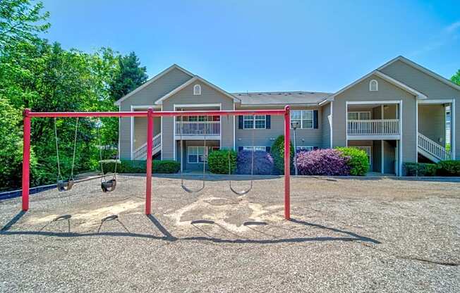 a swing set in front of an apartment building