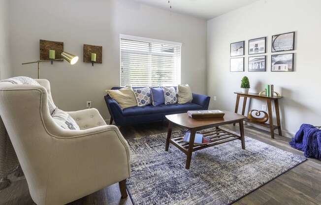 a living room with a blue couch and two white chairs