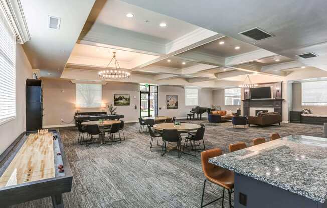 a resident clubhouse with tables and chairs and a foosball table at The Beckstead, South Jordan, UT