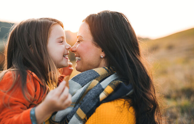 a mother and daughter smiling at each other at Brownstones at Palisade Park Townhomes, Broomfield, 80023