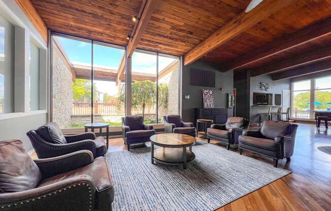 A living room with brown leather chairs and a wooden ceiling.