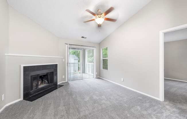 a living room with a fireplace and a ceiling fan