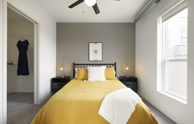 a bedroom with a large yellow bed and two windows