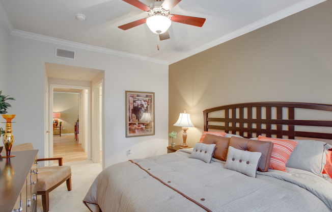 View of Bedroom with Ceiling Fan, Bed, and Carpet at Raveneaux Apartments