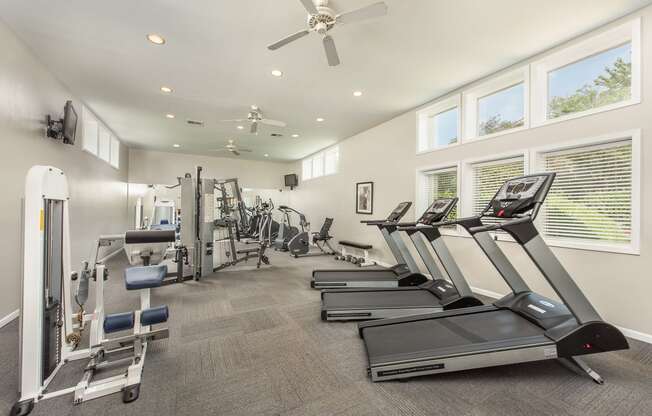 a gym with cardio machines and a ceiling fan at Highland Ridge Apartments, Kansas