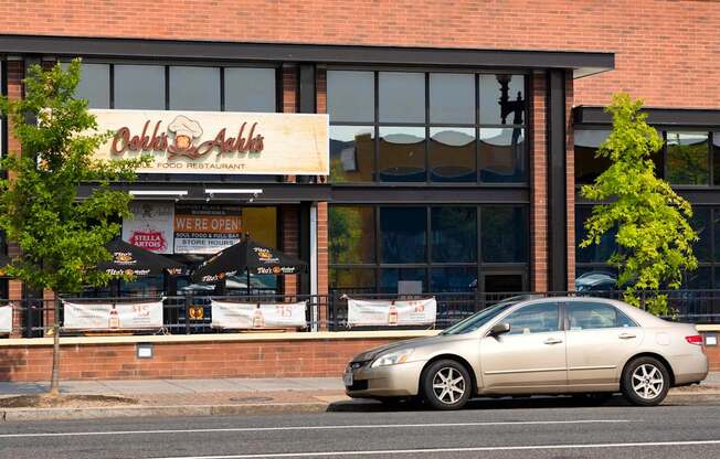 A car is parked in front of a restaurant.
