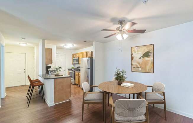 a living room with a dining room table and a kitchen at Sanger Place, Lorton, VA