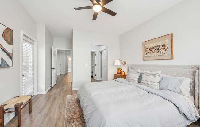 A bedroom with a large bed and a ceiling fan.