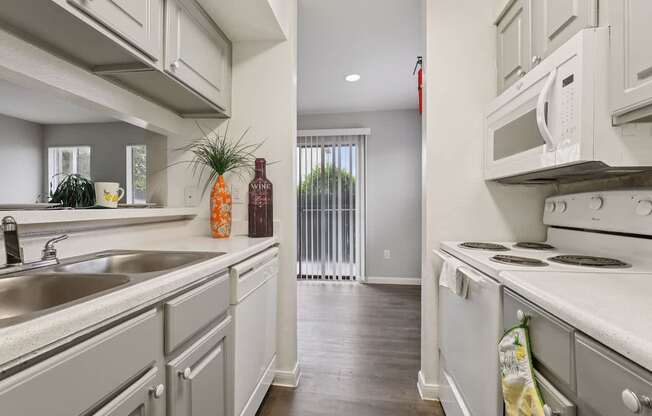 A kitchen with white cabinets and a stainless steel sink.