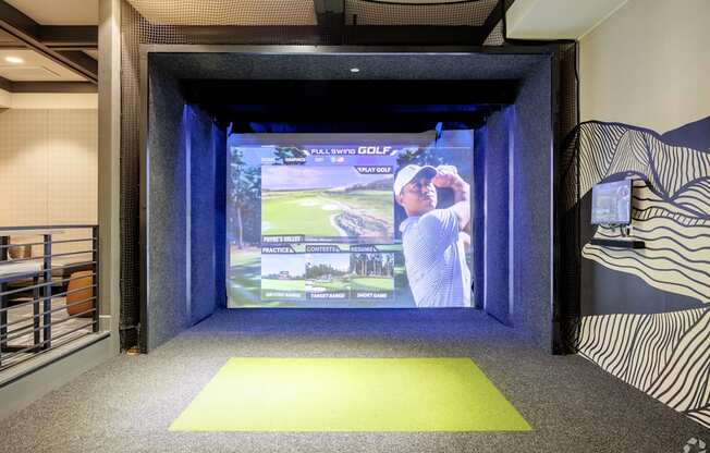 A room with a screen showing a man playing golf.