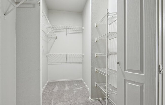 A white hallway with a carpeted floor and a door on the right.