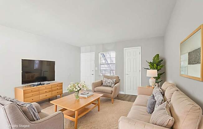 A living room with a couch, chairs, and a coffee table.