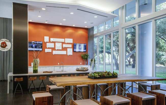 a kitchen with a wooden table and chairs and large windows