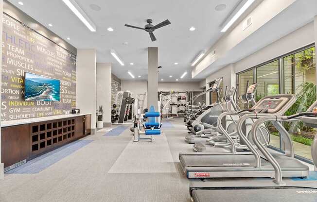 A gym with treadmills and a wall of motivational words.