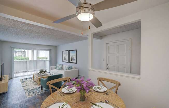 a living room with a ceiling fan and a dining table