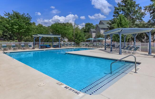 Swimming pool with covered deck seating at Ashley Oaks Apartments in Greensboro, North Carolina