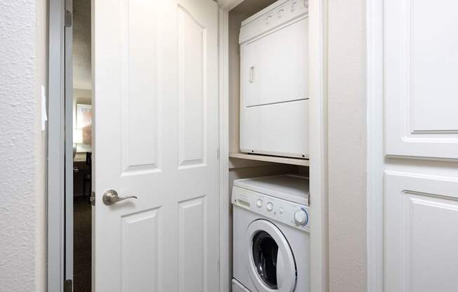 a white washer and dryer in a small laundry room