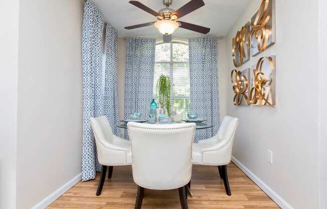 a dining room with a ceiling fan and a window