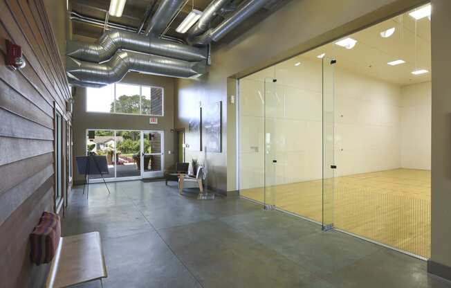 a large room with glass doors and a ping pong table at Village Club of Rochester Hills, Shelby Township