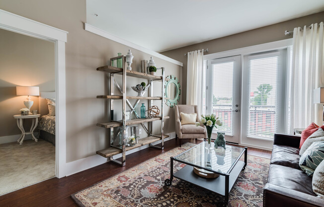 View of Living Room, Showing Doors to Balcony and View of Bedroom at Alpha Mill Apartments